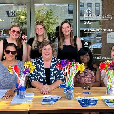 Staff members hand out pinwheels and information to Third Thursday participants.